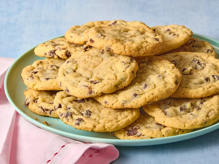 A plate with several chocolate chip cookies.